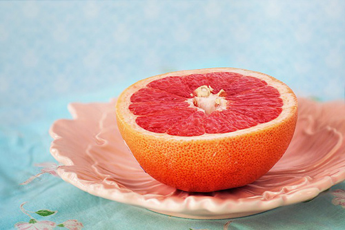 half of grapefruit on a saucer on a table