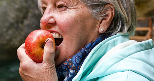 older woman eating an apple