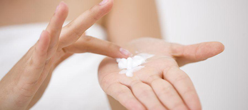 hands preparing dermatitis cream for distribution over the skins affected areas
