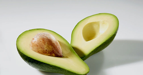 Avocado cut into two with seed on one side