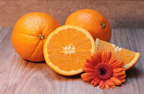 slices of oranges on a table with an orange flower