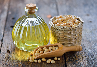 soybeans in small wicket cup and a bottle of soybean oil