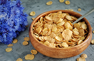 wooden bowl of wheat flakes