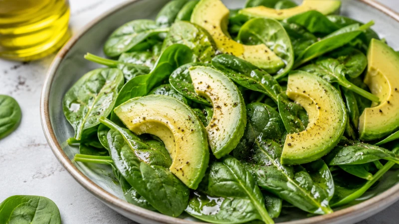 Spinach salad with olive oil and avocado.