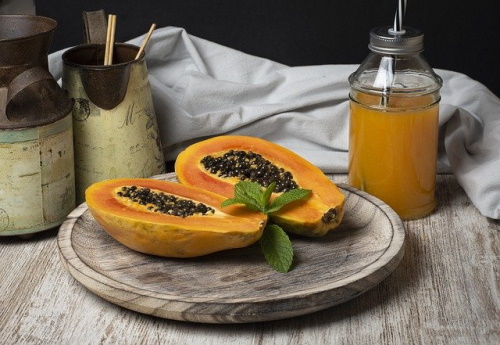 Foods for healthy digestion: Image of cut open papaya and a glass jar of papaya juice.