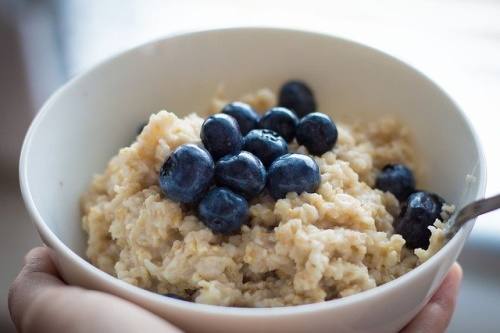 Foods that boost your metabolism: Image of a big bowl of oatmeal cereal with blueberries on top.