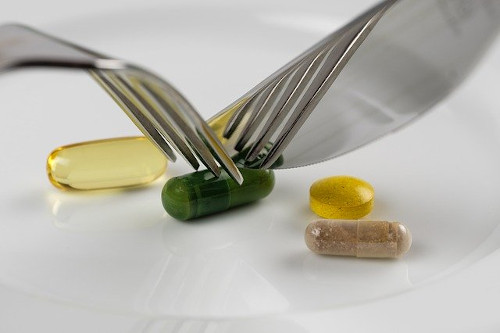 Image of Vitamins being manipulated with a spoon and fork.