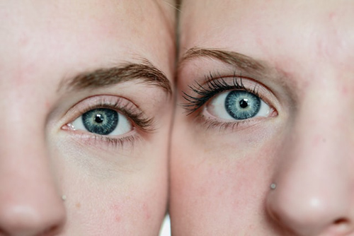 closeup on the the beautiful blue eyes of two women with their faces cheek to cheek