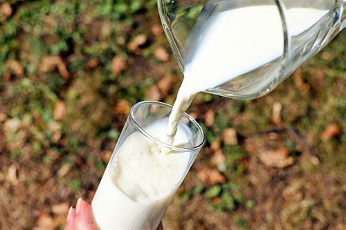 Pitcher of milk being poured into a glass