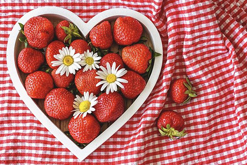 Heart shaped vessel with strawberries within it