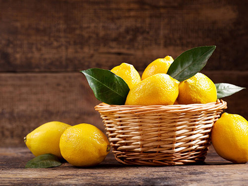 Beautiful yellow lemons inside and outside of a basket