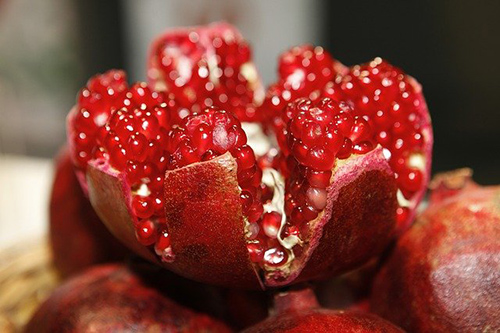 A ripened delicious and juicy looking pomegranate that was ripped open displaying its juicy contents