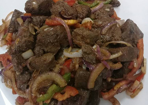 plate of cooked beef liver suauted with onions and other vegetables