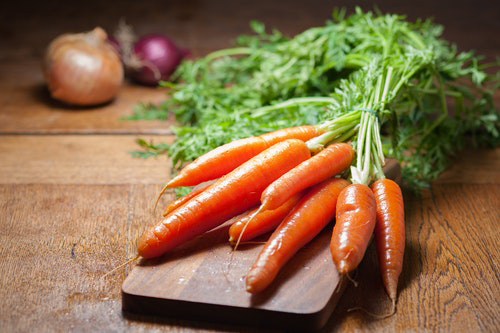 Bunch of carrots on a cutting board.