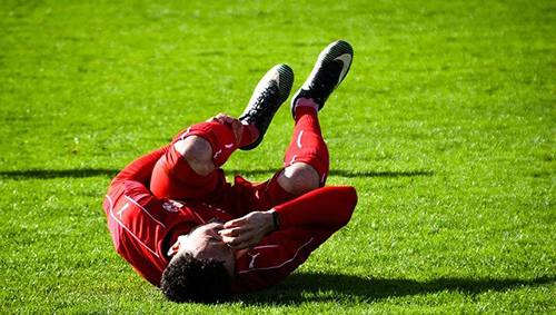 Athlete on the field in pain due to leg cramps