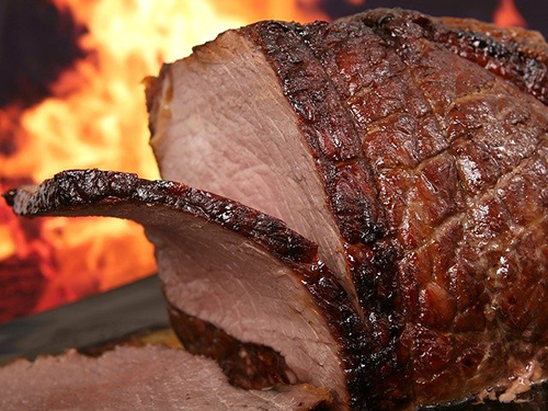 pot roast being sliced with a fire in the background