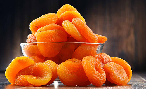 bowl of dried apricots overflowing on the table