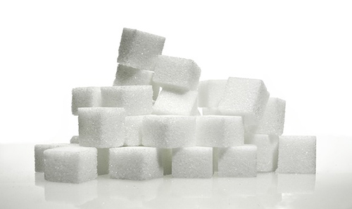 quite a few cubes of white sugar on a table waiting to be consumed