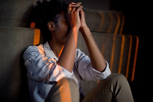 woman sitting on the ground clearly suffering from depression and anxiety