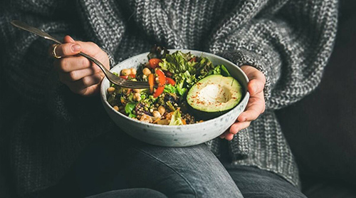 person sitting with plate of macrobiotic foods in a bowl