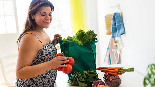 woman with grocery bag filled with macrobiotic diet foods