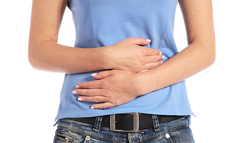 woman holding her stomach with both hands clearly in stomach pain