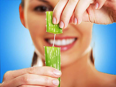woman with a cut open stalk of aloe which is one of the best herbs for inflammation