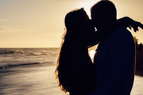 silhouette of a couple hugging on the beach