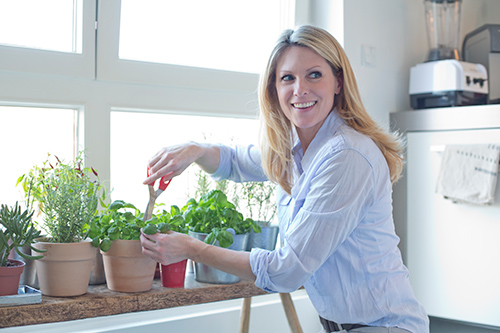 herbs for women: woman in her kitchen cutting herbs