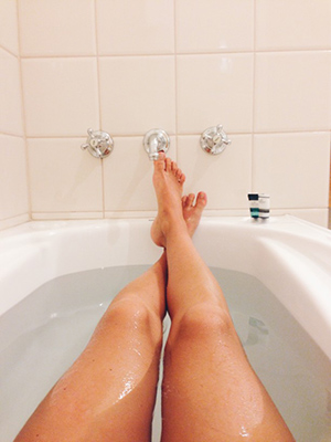 the legs of a woman stretched out in a tub filled with water