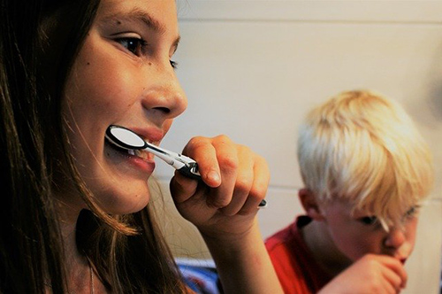 woman and child in the bathroom brushing their teeth