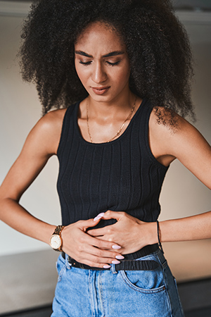 woman holding her midsection because of intestinal disorders