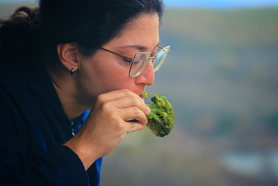 woman eating broccoli