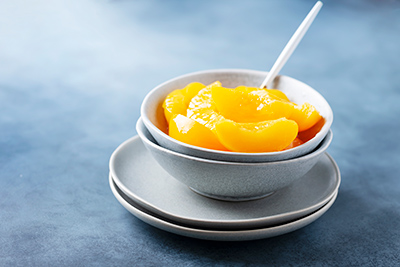 peaches in bowl of syrup