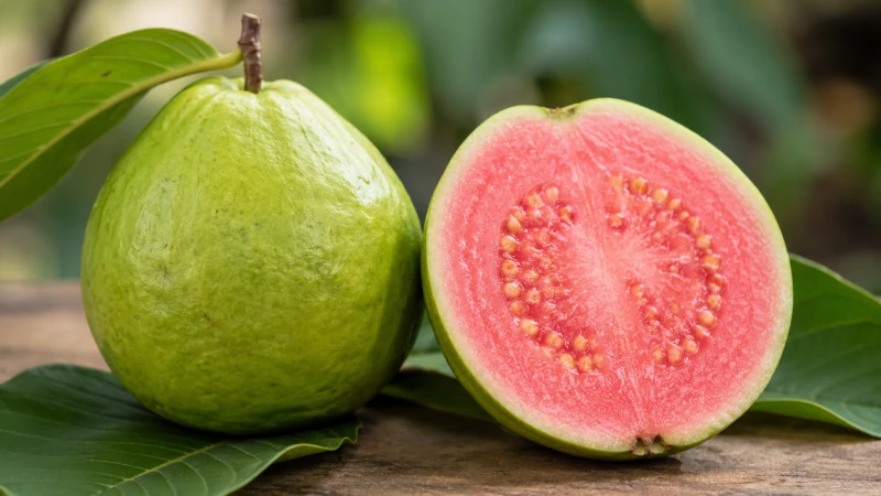 Fresh guava fruit halved showing seeds and pink flesh.