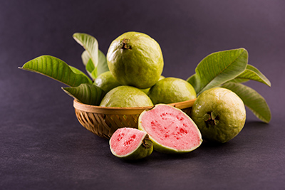 guavas in a bowl along with leaves