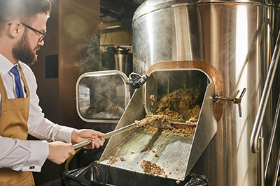 man hard at work performing the malting process