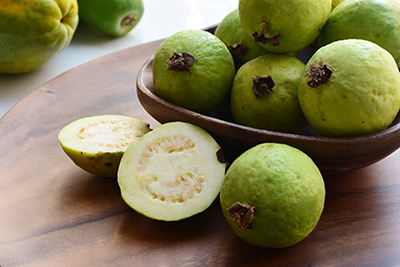 bowl of guavas on a table.