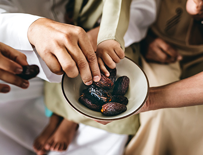 group of people sharing dates from a bowl