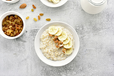 a bowl of oat meal with bananas and nuts