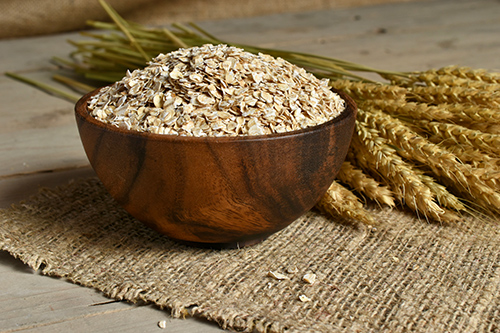 health benefits of oats: raw oats in a wooden bowl