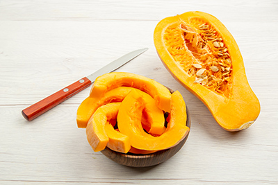 squash sliced up with the knife next to it