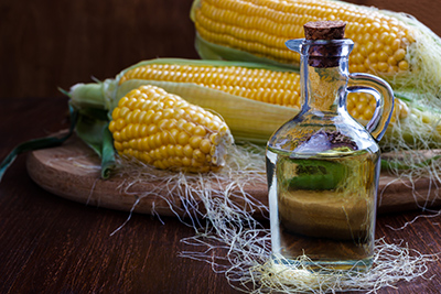 corn next to a bottle of corn oil