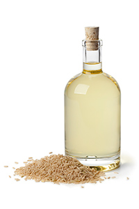 bottle of rice bran oil with brown rice at the base