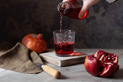 pouring pomegranate juice into a glass