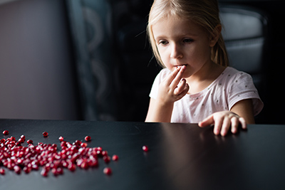 little girl eating pomegranate