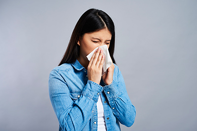 woman sneezing due to allergies