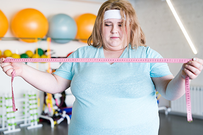 obese woman holding measuring tape