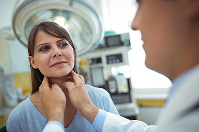 doctor checking a woman's thyroid gland