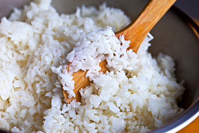 bowl of white rice with a wooden spoon